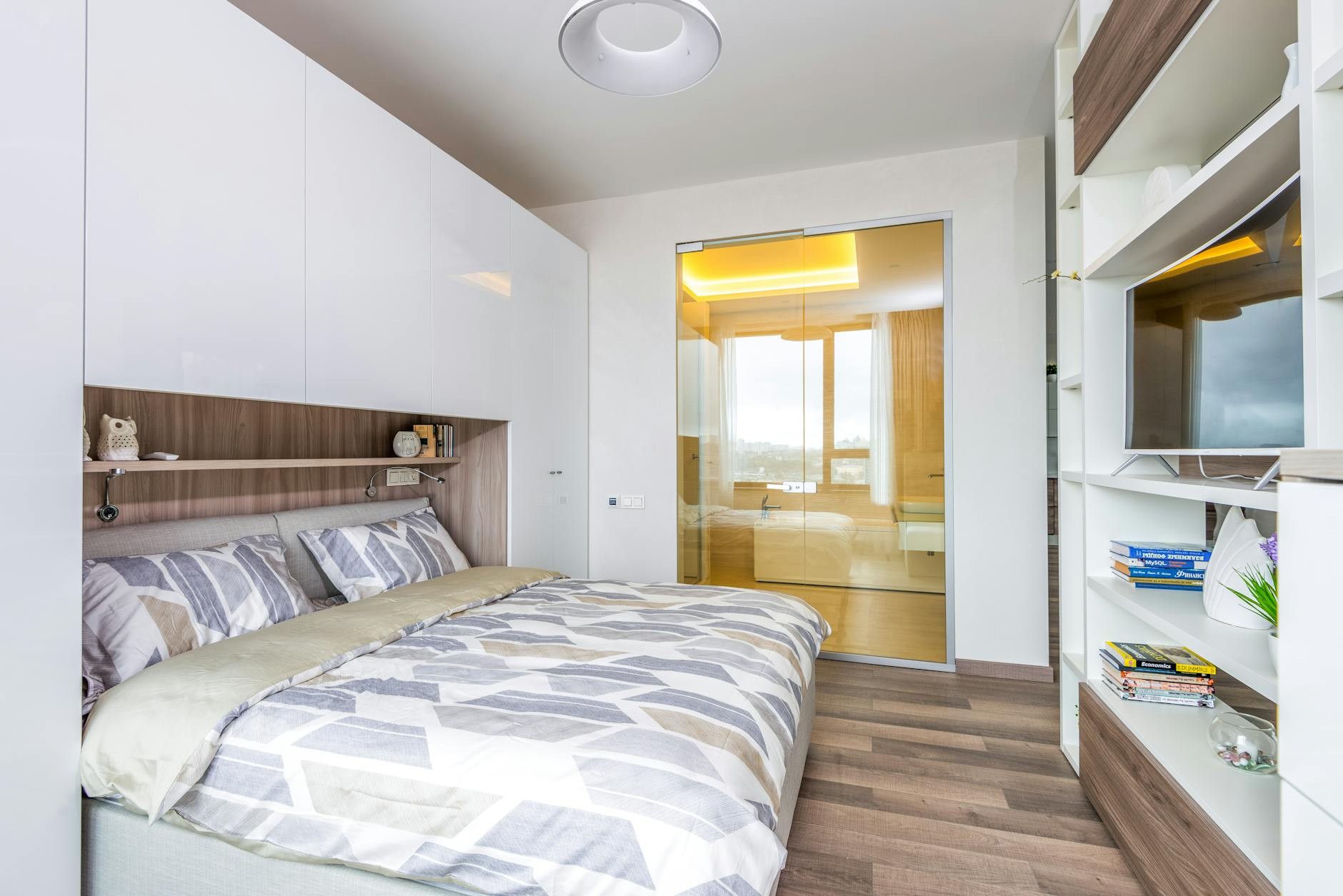 Calm, organized bedroom interior with fitted parabet wardrobe and alcove shelving